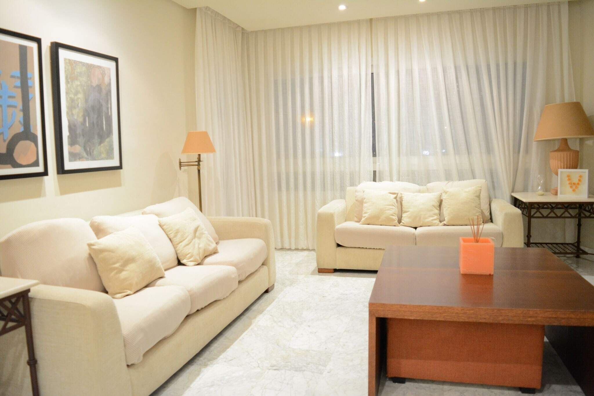 Ein modernes Wohnzimmer mit zwei Sofas, einem Couchtisch und einer Lampe.