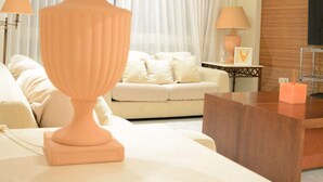 Uma sala de estar com sofá, mesa de centro e abajur.