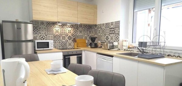 Una cocina compacta equipada con microondas, cafetera y lavavajillas.