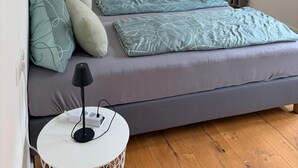 Ett sovrum med en säng, ett nattduksbord, en lampa och en garderob.