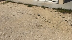 Un edificio de dos pisos con techo plano, un amplio ventanal corredero y una ventana pequeña en el nivel superior.