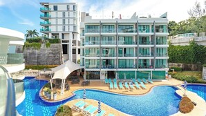 Un hotel moderno con piscina, numerosi balconi e terrazza panoramica.