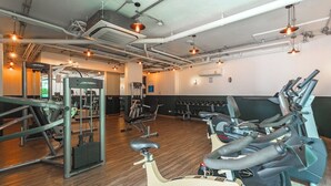 Una palestra con attrezzature per esercizi, tra cui tapis roulant e macchinari per pesi.