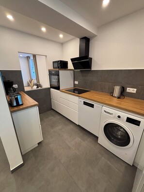 A modern kitchen with a built-in dishwasher, a microwave, and a stove. - Modern bungalow Parking lot Kitchen Quiet DU (Duisburg)