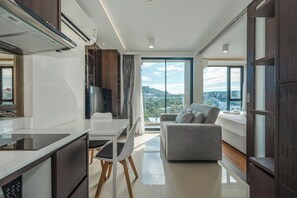 Eine moderne Küche mit Essbereich, einer Couch und einem großen Fenster mit Blick auf die Stadt.