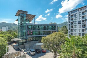 Ein modernes Gebäude mit Glasfassade, einer Dachterrasse und einem Schild, das ein medizinisches und Wellness-Zentrum kennzeichnet.