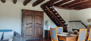 Ein Essbereich mit einem Holztisch, Stühlen und einem großen Schrank.