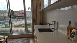 Una cocina moderna con un amplio ventanal, un lavamanos y una botella de licor en la encimera.
