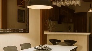 A dining area with a white table, black chairs, a chandelier, and a wooden partition. - Comfort and peace of mind (Santo Domingo Este)