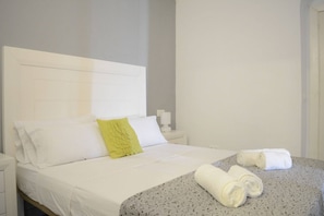 Ein Hotelzimmer mit einem Bett, einem Nachttisch und einem auf dem Bett liegenden Handtuch.