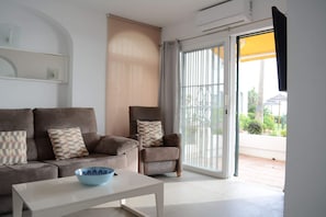 Ein Wohnzimmer mit einer Couch, einem Sessel und einem Couchtisch.