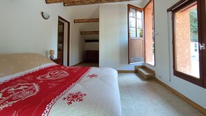 Une chambre à coucher avec un lit, une fenêtre et une porte donnant sur une autre pièce.