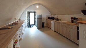 Una cocina tipo ático con mostrador de madera, refrigerador, microondas y lavavajillas.