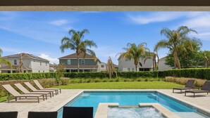 Una piscina amb gandules, un banyera d'hidromassatge i vista a edificis residencials.