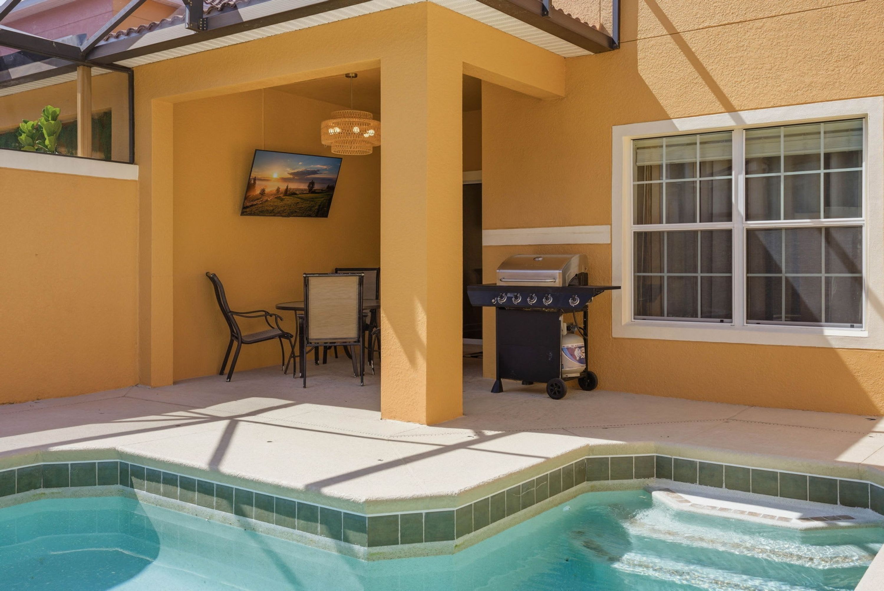 Ein Poolbereich mit Whirlpool, Grill und Essbereich.