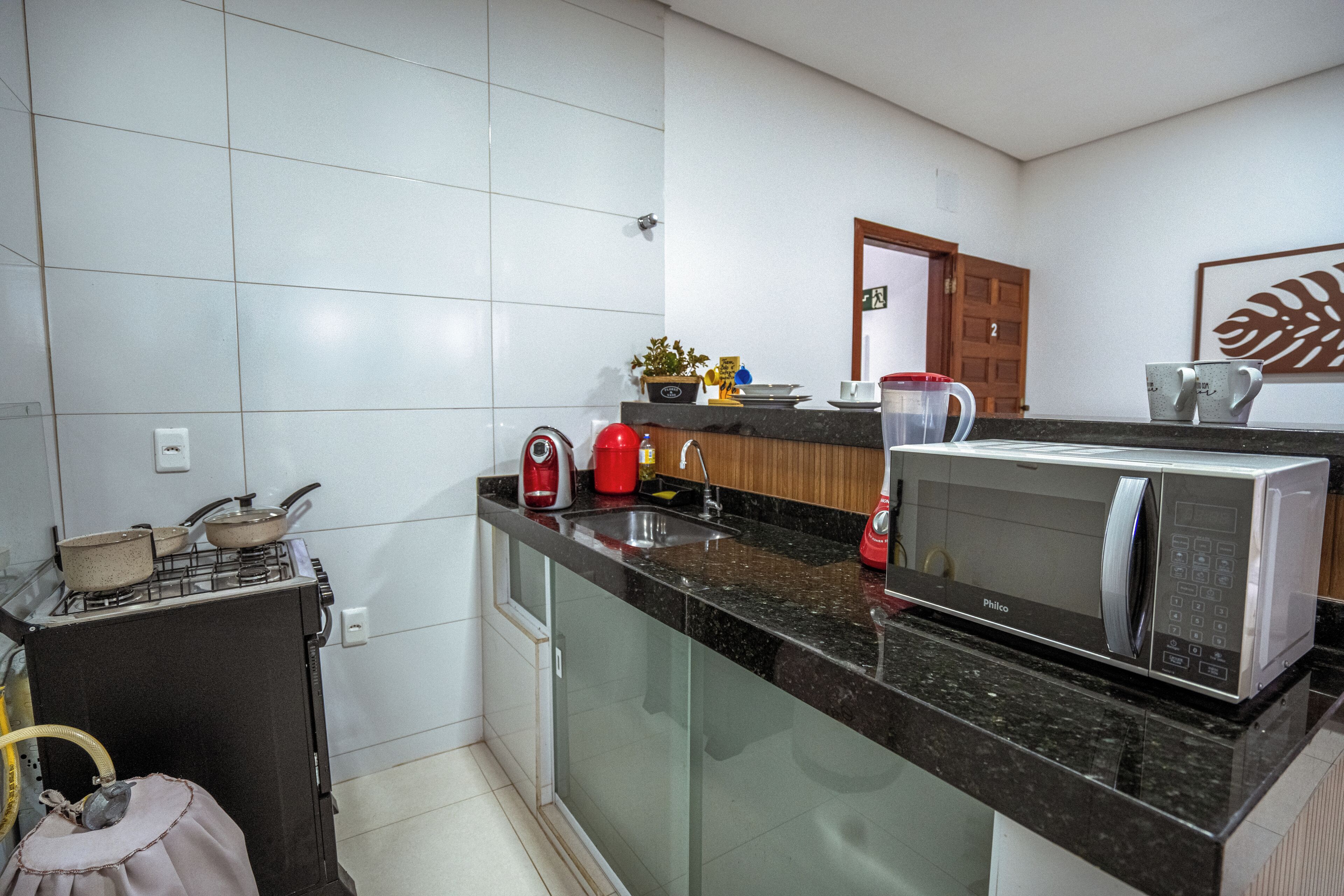 A kitchen with a gas stove, microwave, sink, and cabinets.