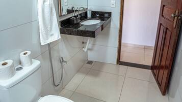 A bathroom with a toilet, sink, and shower.