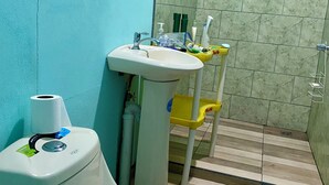 A bathroom with a toilet, sink, and shower. - Marisol House (Quepos)