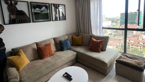 Una sala de estar moderna con un sofá modular, una mesa de centro blanca y cuadros en la pared.
