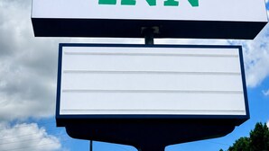 A signboard with 'BAYOU INN' written in green letters on a white background. - Bayou Inn (Jennings)