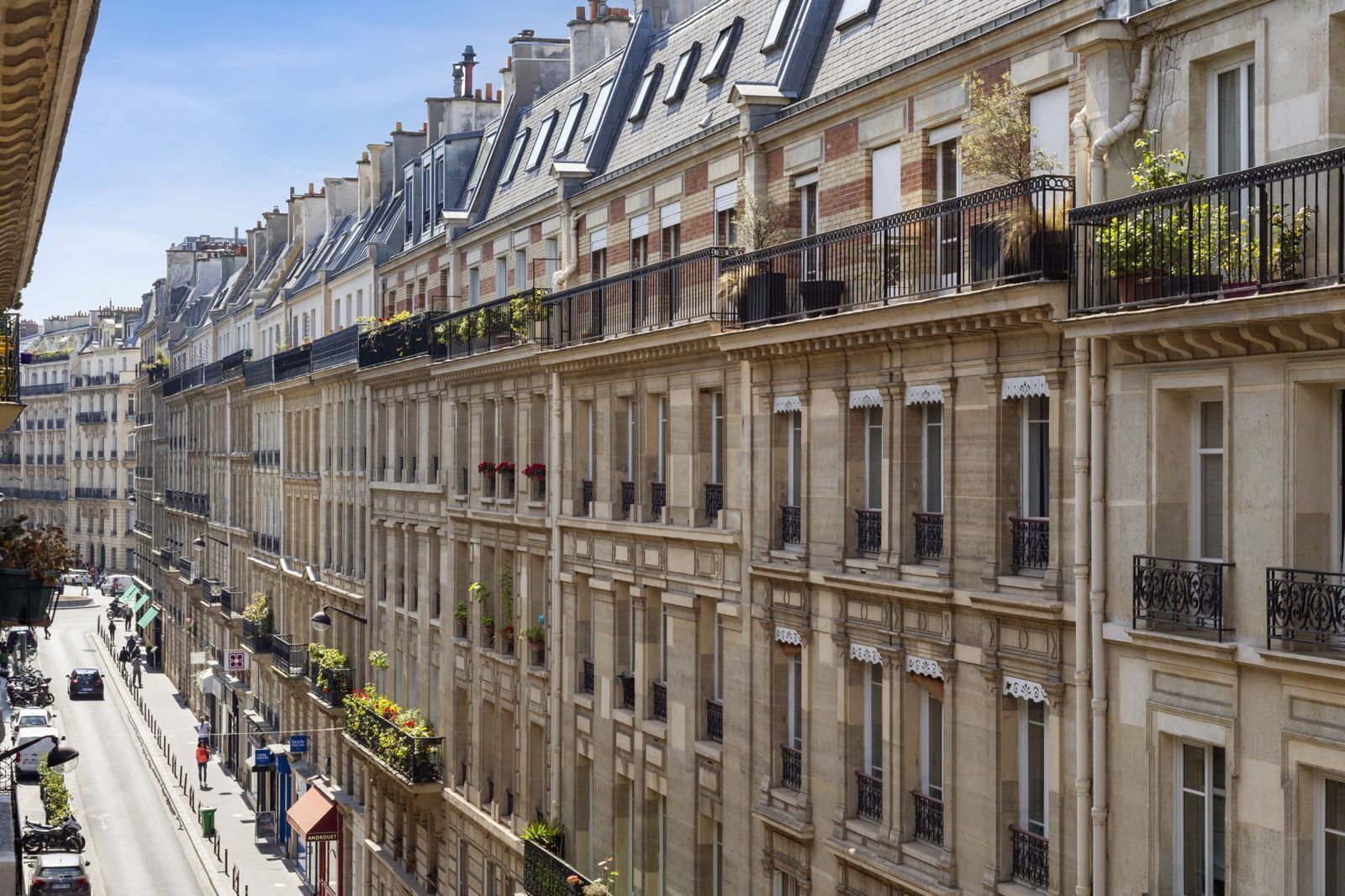 A row of classic European-style buildings with uniform architecture, featuring balconies and windows.