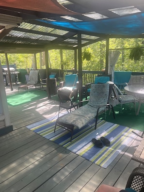 A covered outdoor patio with seating, a grill, and a view of greenery. - 1/2 hour walk to 500 track, huge outdoor space (Indianapolis)