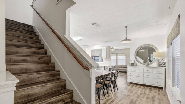 A staircase leading to a dining area with a white ceiling and wooden flooring. - Cozy Downtown Home W/ Beautiful City Views! (Houston)