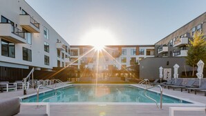 A modern pool area with a clear view of the pool, sun, and surrounding buildings. - Arcadia Oasis w/ Resort Pool, Gym & Fire Pits (Phoenix)