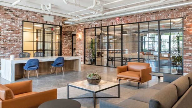 A modern lounge area with brick walls, a reception desk, seating, and large windows. - Arcadia Oasis w/ Resort Pool, Gym & Fire Pits (Phoenix)