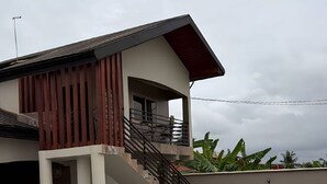 Ein modernes, zweistöckiges Haus mit Treppe, Balkon und einem gepflegten Garten.