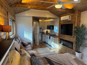 Ein gemütliches Blockhaus mit Wohnbereich, Küche und Kamin.