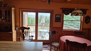 Ein gemütlicher Essbereich mit Tisch und Stühlen, Blick ins Freie und Holzvertäfelung.