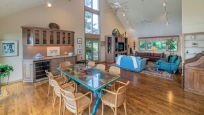 Un salón amplio con una mesa de comedor, sillas, un sofá y un televisor.