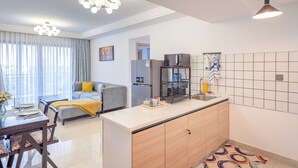 Een modern appartement met keuken, eethoek en woonkamer.