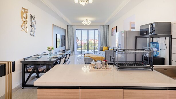 Een moderne keuken met een centraal eiland, een eethoek en een groot raam met uitzicht.