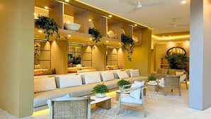 Een moderne woonkamer met een bank, stoelen en een salontafel.