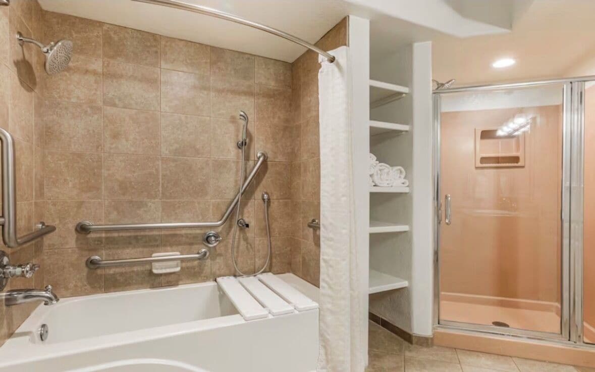 Ein Badezimmer mit Badewanne, Dusche und einer gläsernen Duschkabine.