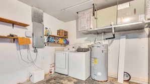 A laundry room with a washing machine, dryer, and water heater. - Cozy 1-bedroom house with AC in delightful North Port (North Port)