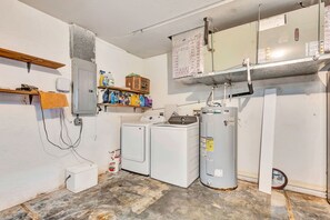 Ein Waschraum mit Waschmaschine, Trockner und Warmwasserbereiter.