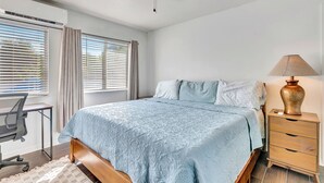 A bedroom with a bed, bedside table, lamp, desk, chair, and window with blinds. - Cozy 1-bedroom house with AC in delightful North Port (North Port)