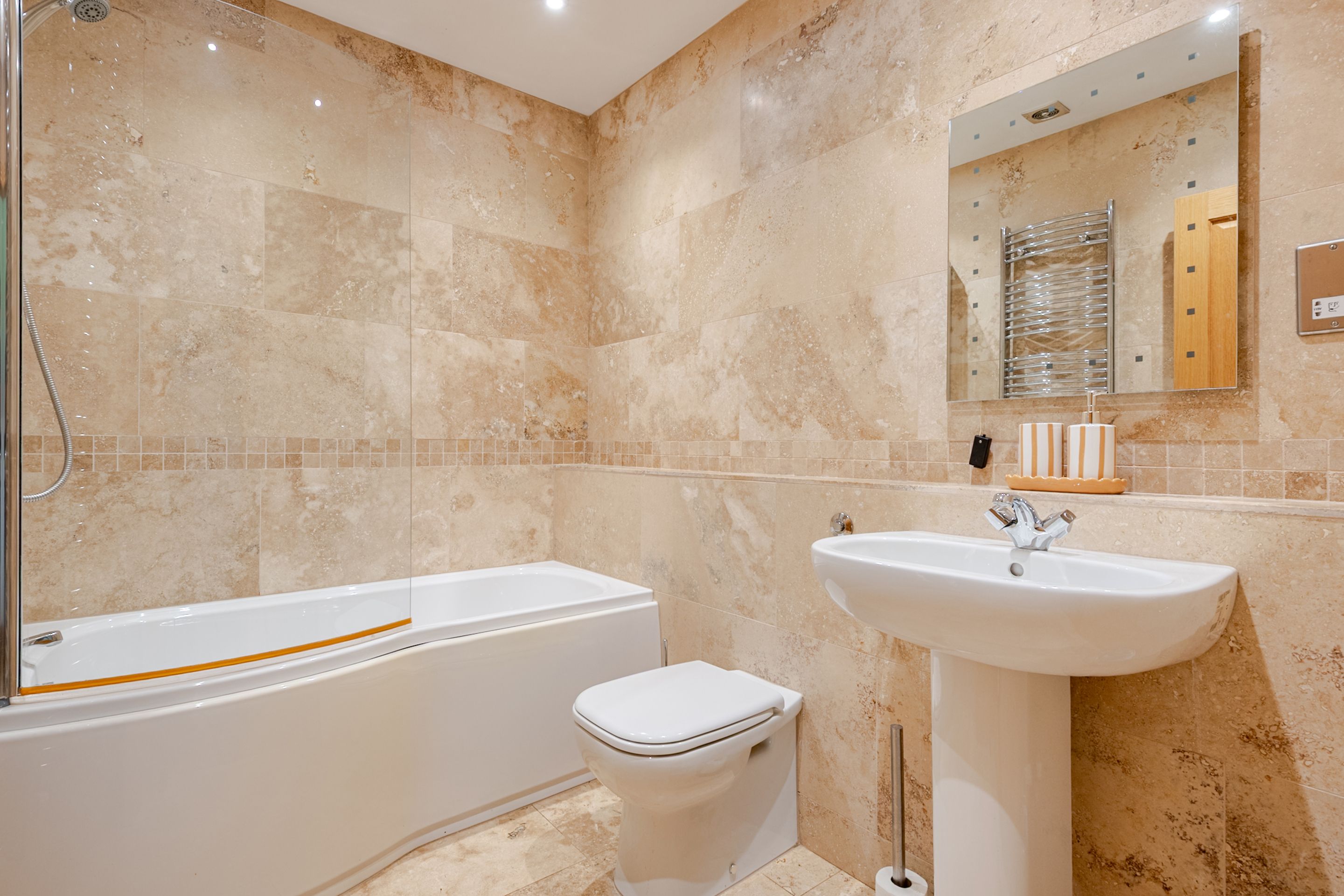 A bathroom with a bathtub, toilet, and sink.