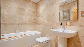 A bathroom with a bathtub, toilet, and sink.