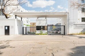 Una entrada portonada a un edificio moderno con un paseo techado, un letrero que dice 'THE MONROE' y un cielo despejado.
