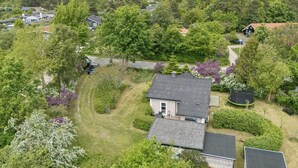 An aerial view of a residential area with houses, a grassy yard, and a trampoline. - Cozy cottage in Nykøbing Sjælland (Nykøbing Sj)