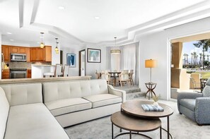 Ein modernes Wohnzimmer mit einer Couch, einem Couchtisch und einem Essbereich mit Stühlen und einem Tisch.