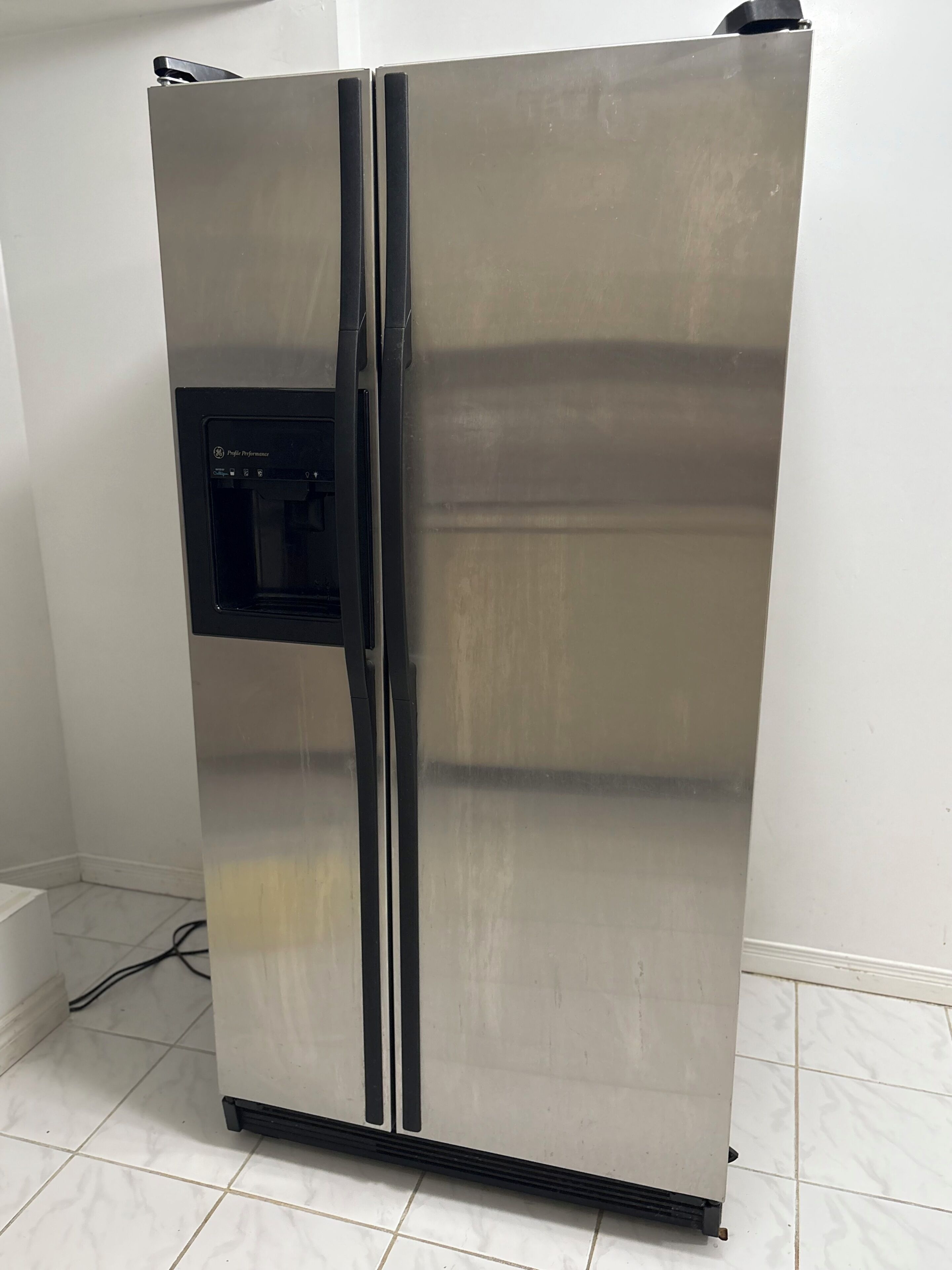A stainless steel refrigerator with a freezer compartment on the left, a water dispenser, and a control panel.