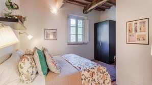 Ein Schlafzimmer mit Bett, Fenster, Kleiderschrank und Lampe.