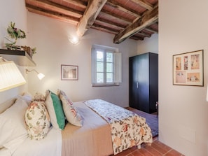 A bedroom with a bed, a window, a wardrobe, and a lamp. - Apartment in Tuscany With Stunning Views (Capannori)