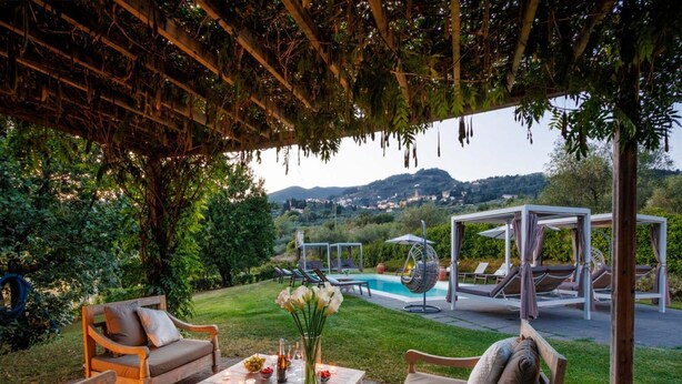 Eine Außenpatio mit Sitzgelegenheiten, einem Pool und Blick auf die Landschaft.