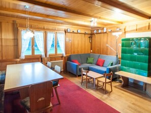 A cozy room with a wooden interior, a sofa, a dining table, and a bench. - Vacation home Lorenz by Interhome (Flüeli-Ranft)